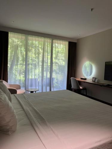 a bedroom with a large bed with a large window at Flamingos Cat Ba pre núi in Cat Ba