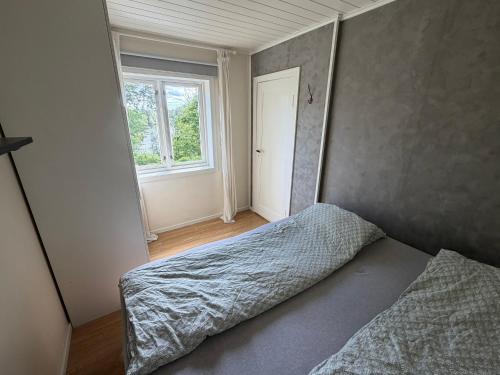 a bedroom with a bed and a window at Charming sea view in Bergen