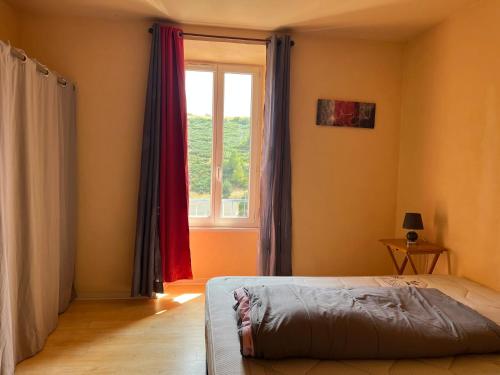 a bedroom with a bed and a window at Appartement le Gallon in Langogne