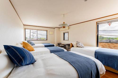 a room with four beds and a window at DAI HOSTEL Ayase in Fukaya