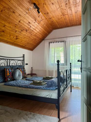 a bedroom with a bed with a wooden ceiling at Kovács Vendégház in Harkány