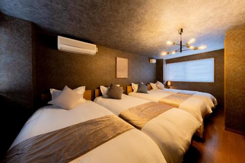 a row of beds lined up in a room at DAI HOSTEL Ayase in Fukaya