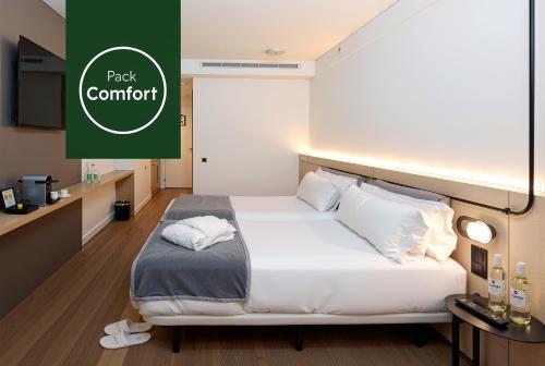 a hotel room with a bed and a sign that reads pack comfort at Sercotel Delfos Andorra in Andorra la Vella
