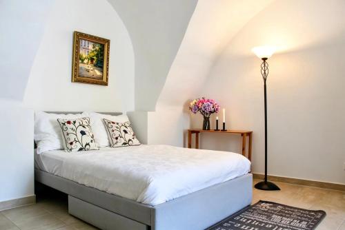 a bedroom with a bed with white sheets and pillows at Historic Flat & Private Courtyard in Bruck an der Leitha
