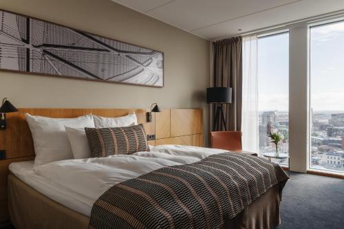 a bedroom with a large bed and a large window at Clarion Hotel Malmö Live in Malmö