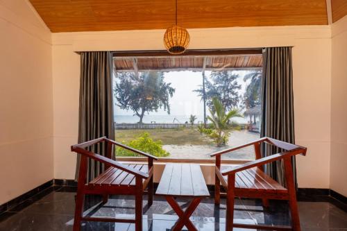 a dining room with a table and two chairs and a window at Sea Shells Beach Resort Agatti in Agatti