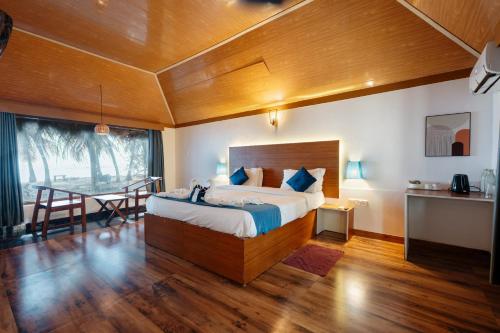 a bedroom with a large bed and a table at Sea Shells Beach Resort Agatti in Agatti
