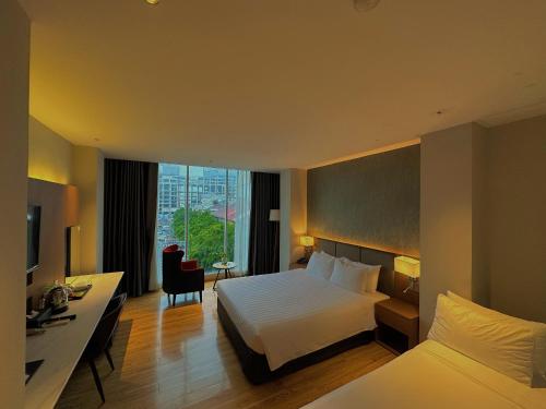 a hotel room with a bed and a desk at Ngan Ha Hotel - Ben Thanh Central in Ho Chi Minh City