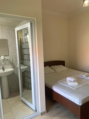 a bedroom with a bed and a sink and a mirror at LouNik stay hotel and rooms in Kobuleti