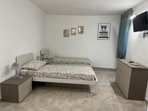 a bedroom with two beds and a television in it at La Bella e La Bestia in Lierna