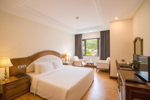 a hotel room with a bed and a television at Sai Gon Ha Long Hotel in Ha Long