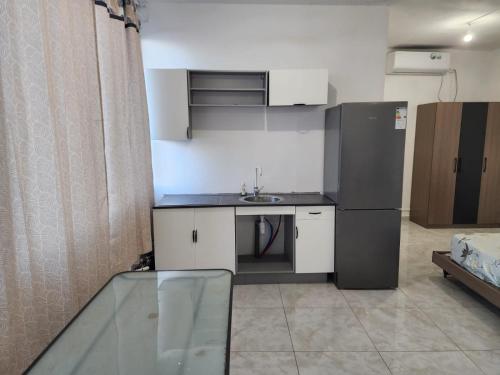 a small kitchen with a sink and a refrigerator at Entre Ciel et Lagon in Mtsamboro