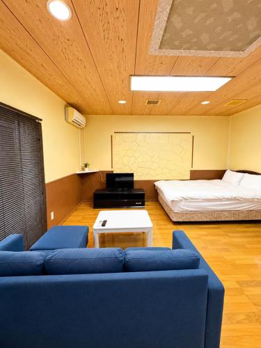 a living room with a couch and a bed at Local LifeYOMITAN in Yomitan