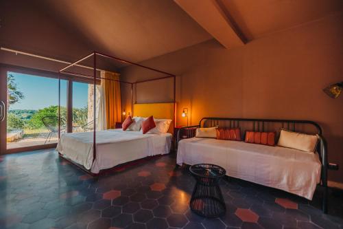 a bedroom with two beds and a large window at VILLA SUMAC 6, Emma Villas in Sortino