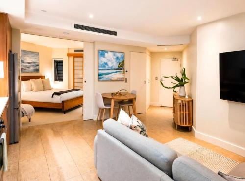 a living room with a couch and a bed at Bugalmaa - Cotton Beach in Casuarina