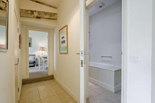 a bathroom with a tub and a walk in shower at Giddy Cottage in Eastdean