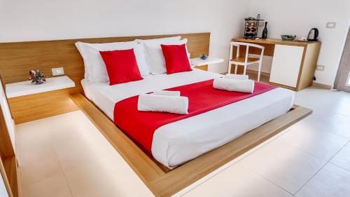 ein Schlafzimmer mit einem großen Bett und roten Kissen in der Unterkunft Corallo Home Resort in Le Castella