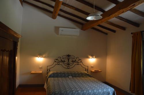 a bedroom with a bed with two lights on it at La Felce e il Mirtillo in Il Palazzo