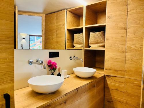 two sinks on a wooden counter in a bathroom at GuestHost - Mulino del Bianco - Comfy Studio-Flat in La Thuile