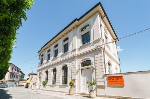 a white building with potted plants in front of it at Miramare Apartments&Suites in La Spezia