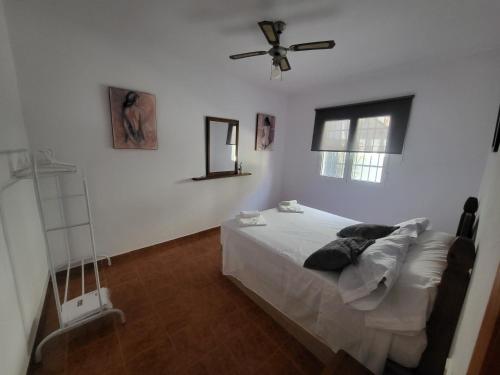 a bedroom with a bed and a ceiling fan at La Casita del Mar in Torrox