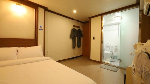 ein Schlafzimmer mit einem Bett und einer Glasschiebetür in der Unterkunft Dal Hotel in Seoul