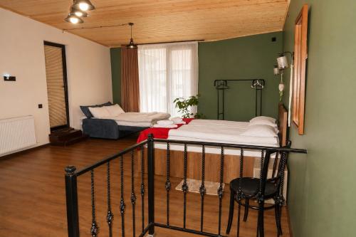 a room with two beds and a chair in it at The Fireplace ROOM in Borjomi
