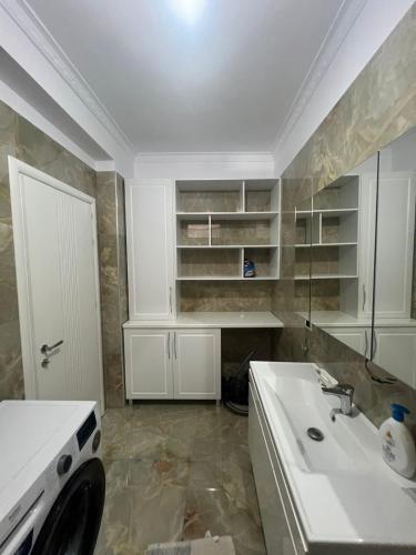 a white kitchen with a sink and a counter at Twobedrooms house in Polisi i Vogël