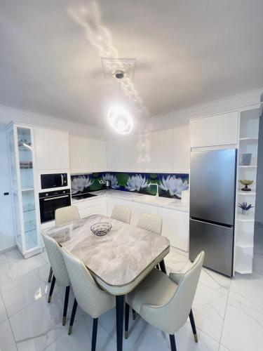 a kitchen with a table and chairs and a refrigerator at Twobedrooms house in Polisi i Vogël