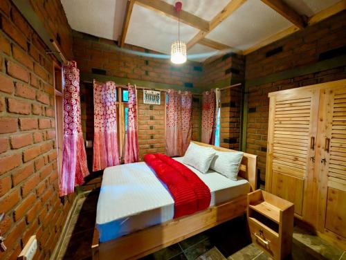 a bedroom with a bed in a brick wall at Kijani Pazuri Cottages in Lushoto