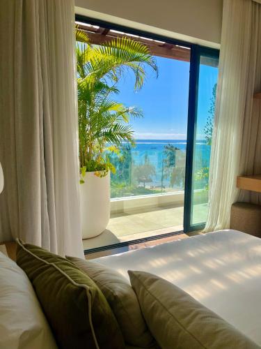 a bedroom with a large window with a view of the ocean at Breathtaking seaview penthouse - Belle Mare in Post of Flacq