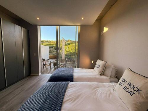 a hotel room with two beds and a balcony at Horizon House in Mossel Bay
