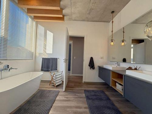 a large bathroom with a tub and two sinks and a tub at Horizon House in Mossel Bay