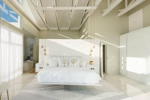 a large white bedroom with a large white bed at White Water Retreat - Pinnacle Point in Mossel Bay