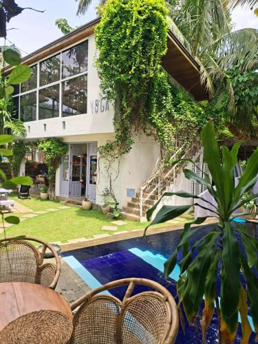a villa with a swimming pool in front of a house at Salt House in Hiriketiya