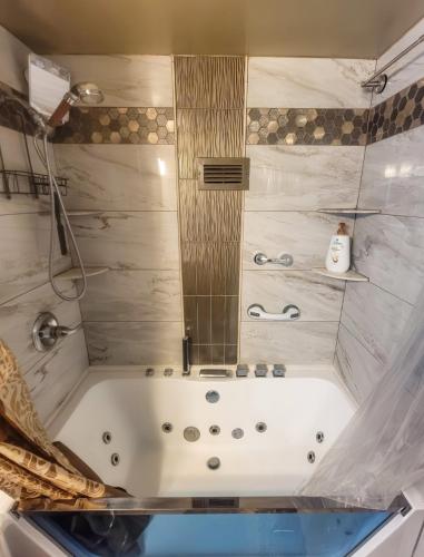 a white bath tub with a mirror in a bathroom at The River Condos in Detroit