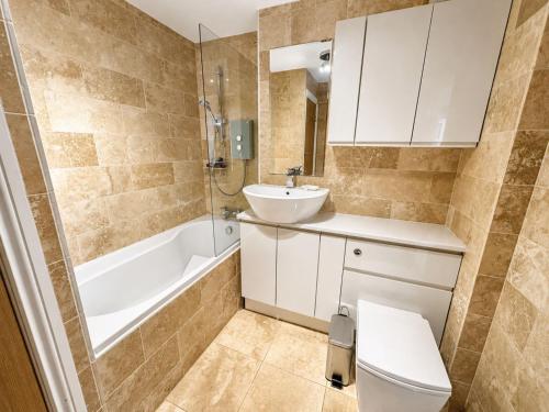 a bathroom with a toilet and a sink and a bath tub at Dog friendly sea front apartment with balcony in Pendine
