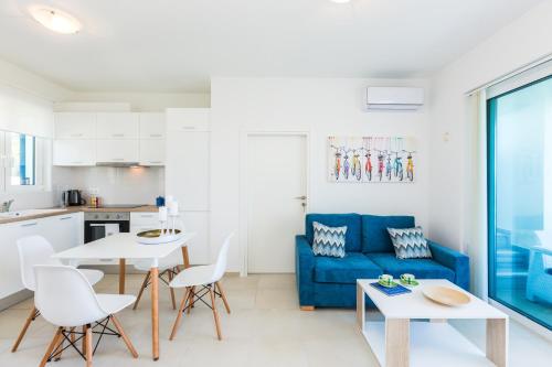 a living room with a blue couch and a table at Triton Sea View Villa in Georgioupolis