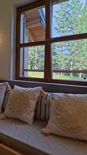 a couch with pillows in front of a window at Vig in Njegovuđa
