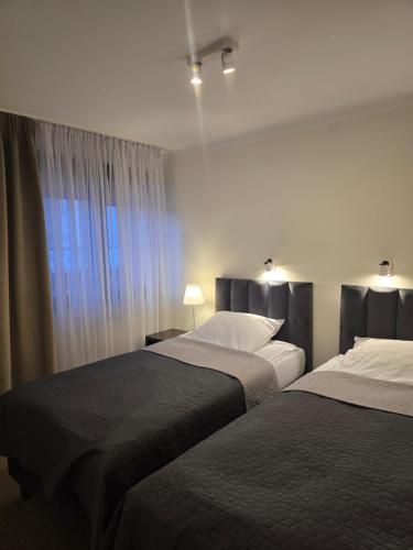 a hotel room with two beds and a window at Inter Hotel in Ostrołęka