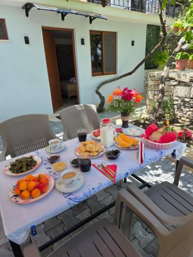 a table with plates of food on a patio at Guest House Mene in Gjirokastër