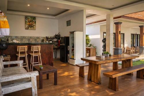 a kitchen and living room with wooden tables and chairs at AA Guest House Padonan in Dalung