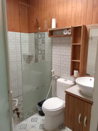 a bathroom with a toilet and a sink and a shower at AA Guest House Padonan in Dalung