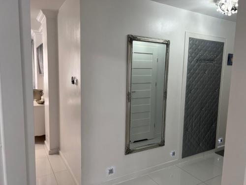 a bathroom with a mirror on a white wall at Apartament Chanel Centrum in Malbork