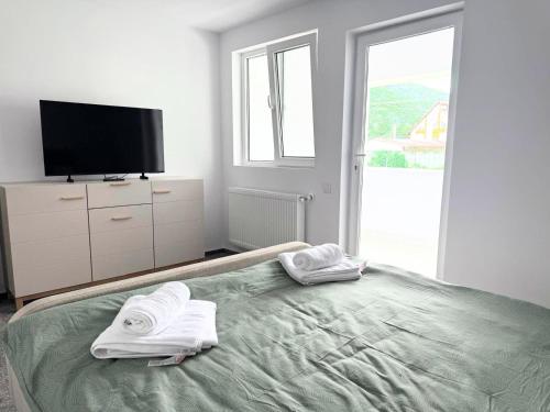 a bedroom with a bed with two towels on it at Păușa Residence in Păuşa