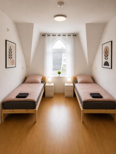 two beds in a room with a window at Wohnliches Apartment in Koblenz-Bubenheim in Koblenz