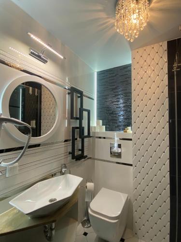 a bathroom with a sink and a toilet and a mirror at Dom Wczasowy Stenka in Gowidlino