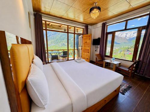 a bedroom with a bed with a view of a mountain at Hotel Naina Rockland , Manali in Vashisht