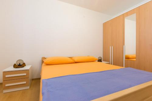 - une chambre avec un lit et une armoire en bois dans l'établissement Apartment Polugic, à Punat