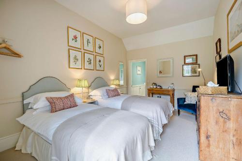 a bedroom with two beds and a tv in it at Tiger Inn - Grace in Eastbourne
